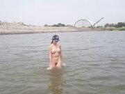 Naked girl masturbates on the river shore